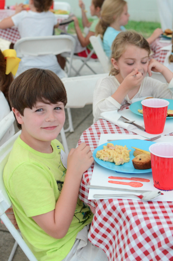  Pre-Beginners enjoy a lunch of macaroni and cheese with ham, blueberry muffins, and apple slices 